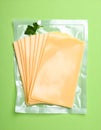 Pack of sliced, Cheese on green background, top view Royalty Free Stock Photo