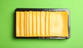 Pack of sliced, Cheese on green background, top view Royalty Free Stock Photo