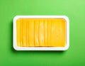 Pack of sliced, Cheese on green background, top view Royalty Free Stock Photo