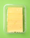 Pack of sliced, Cheese on green background, top view Royalty Free Stock Photo