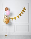 Balloon garland near white wall in room. Festive decor Royalty Free Stock Photo