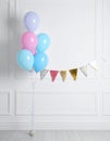 Balloon garland near white wall in room. Festive decor Royalty Free Stock Photo