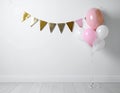 Balloon garland near white wall in room. Festive decor Royalty Free Stock Photo