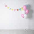 Balloon garland near white wall in room. Festive decor Royalty Free Stock Photo