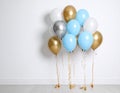 Balloon garland near white wall in room. Festive decor Royalty Free Stock Photo
