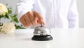 Man ringing hotel service bell at light table Royalty Free Stock Photo