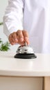 Man ringing hotel service bell at light table Royalty Free Stock Photo