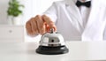 Man ringing hotel service bell at light table Royalty Free Stock Photo