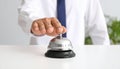 Man ringing hotel service bell at light table Royalty Free Stock Photo