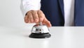 Man ringing hotel service bell at light table Royalty Free Stock Photo