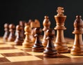 Many chess pieces on wooden checkerboard against black background, selective focus Royalty Free Stock Photo