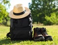 Backpack, hat and trekking shoes on grass in the open air Royalty Free Stock Photo