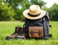 Backpack, hat and trekking shoes on grass in the open air Royalty Free Stock Photo