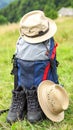 Backpack, hat and trekking shoes on grass in the open air Royalty Free Stock Photo
