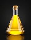 Glass flask with yellow oil on black background, closeup. Royalty Free Stock Photo