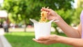 Woman eating takeaway noodles from paper box with fork outdoors, closeup. Street food Royalty Free Stock Photo