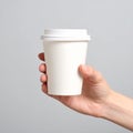 A woman holding a paper cup in front of a gray background. Creating a model Royalty Free Stock Photo