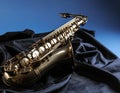 Jazz. A beautiful saxophone on dark fabric against a light blue background. Text area Royalty Free Stock Photo