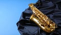 Jazz. A beautiful saxophone on dark fabric against a light blue background. Text area Royalty Free Stock Photo