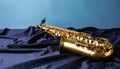 Jazz. A beautiful saxophone on dark fabric against a light blue background. Text area Royalty Free Stock Photo