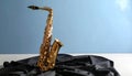 Jazz. A beautiful saxophone on dark fabric against a light blue background. Text area Royalty Free Stock Photo