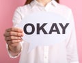 Woman holding paper speech bubble with word Okay on pink background, closeup Royalty Free Stock Photo