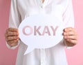 Woman holding paper speech bubble with word Okay on pink background, closeup Royalty Free Stock Photo