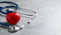 Stethoscope and red heart on grey stone table. Space for text Royalty Free Stock Photo