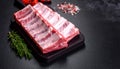 Raw ribs with rosemary and salt on black table, closeup Royalty Free Stock Photo