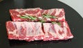 Raw ribs with rosemary and salt on black table, closeup Royalty Free Stock Photo