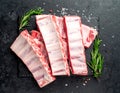 Raw ribs with rosemary and salt on black table, closeup Royalty Free Stock Photo