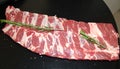 Raw ribs with rosemary and salt on black table, closeup Royalty Free Stock Photo