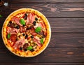 Tasty pizza with cured ham, olives, sun-dried tomato and pepper on wooden table Royalty Free Stock Photo