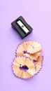 Pencil shavings and sharpener on violet background, flat lay. Space for text Royalty Free Stock Photo