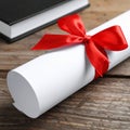 Graduation diploma tied with red ribbon on wooden table, closeup Royalty Free Stock Photo