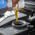 Draining engine oil from the bottle into the car engine, closing Royalty Free Stock Photo