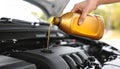 Draining engine oil from the bottle into the car engine, closing Royalty Free Stock Photo