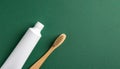 Close-up of bamboo toothbrush and toothpaste tube on minimalist matte dark green background Royalty Free Stock Photo