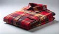 Close-Up of Folded Plaid Flannel Shirt with Autumn Reds and Browns on Matte Light Gray Background Royalty Free Stock Photo