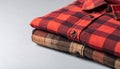 Close-Up of Folded Plaid Flannel Shirt with Autumn Reds and Browns on Matte Light Gray Background Royalty Free Stock Photo