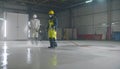 Industrial Cleaning Crew Power Washing a Warehouse Floor Royalty Free Stock Photo