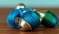 generated using AI.Metallic bobbin holders are wrapped with vibrant blue and green thread. Royalty Free Stock Photo