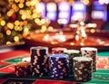 Casino chips on a roulette table against blurry lights. Royalty Free Stock Photo