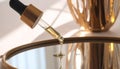 Close-Up of Glass Dropper Releasing Facial Oil onto Mirror Surface Royalty Free Stock Photo