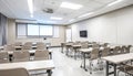 Modern Classroom with Digital Projector, Smartboard, and Neatly Aligned Chairs in Soft Neutral Tones Royalty Free Stock Photo