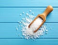 Natural salt and scoop on blue wooden table, top view Royalty Free Stock Photo