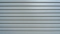 generated using AI.Horizontal metallic siding featuring evenly spaced parallel grooves. Royalty Free Stock Photo