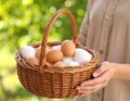 Woman with a basket of raw eggs with blurred background, closed Royalty Free Stock Photo