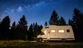 Camper van under starry sky glowing interior pine silhouettes Royalty Free Stock Photo