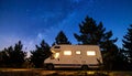 Camper van under starry sky glowing interior pine silhouettes Royalty Free Stock Photo